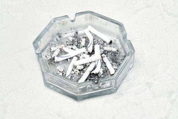 Fototapeta premium Ashtray with cigarette butts on a gray background