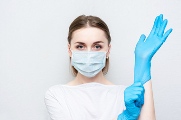 Doctor or nurse in medical mask wears medical gloves, portrait, close up, white background