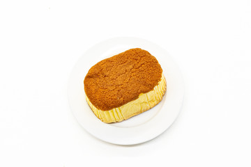 Sponge cake is on white plate and white background .Sponge cake is a light cake made with eggs, flour and sugar, sometimes leavened with baking powder.