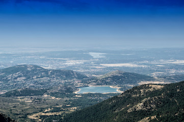plain with reservoir seen from a mountain in national guadarrama park in Madrid. Spain