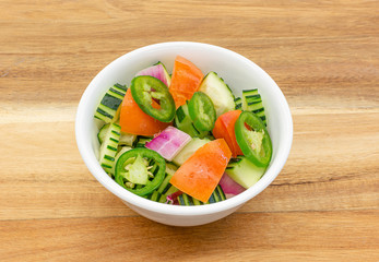 Cucumber Salad homemade (Cucumber,tomatoes,red onions, jalapeno) on wooden background ,top view.