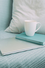 
white mug, blue diary and notebook. light working morning