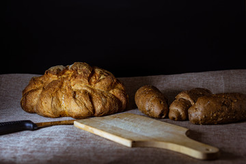 forma de pan casero y pan con cereales y tabla de cortar con cuchillo dentado.