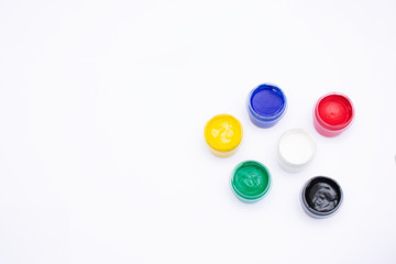 Cans of different colors gouache paints, top view, closeup, white background, copy space