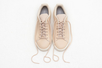 Pair of beige sneakers, inscription cool, white background, top view