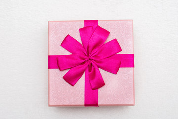 Gift with pink ribbon for Birthday, white background, closeup, top view