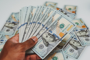 african american man with a stack of US one hundred dollar bills in his hands