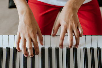 Portrait of male's white hands playing on the piano