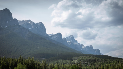 Mountain range with puffy clouds above it, landscape shot made in Canmore, Alberta, Canada