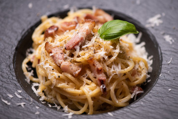 Spagetti carbonara on a black plate