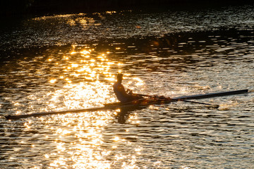 A young male athlete is rowing in a single scull on the Danube, Budapest Hungary