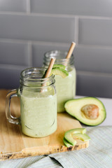 creamy smoothie from avocado and banana in glass cups with paper tubes on a light background. no plastic. healthy food
