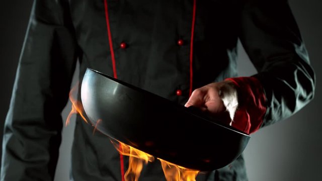 Super slow motion of closeup of chef with empty wok pan and fire. Filmed on high speed cinema camera, 1000 fps.