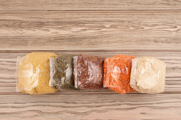 Donation to the needy during the pandemic of the coronavirus Covid-19. Groats in packs on a wooden...