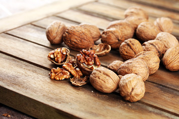 Walnut kernels and group of whole walnuts on rustic old table