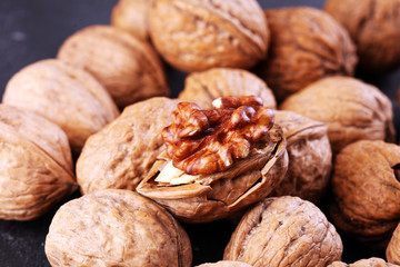 Walnut kernels and group of whole walnuts on rustic old table
