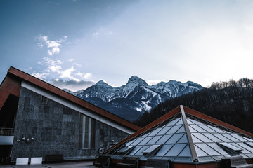 roof a platform for viewing against the backdrop of snow-capped mountains on a winter day. Life in the mountains, hotels for tourists in winter time.