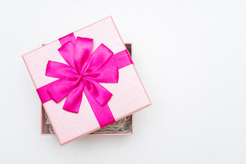 Gift with pink ribbon for Valentine's Day, white background, closeup, copy space, top view