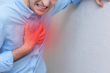 Person clutching his chest from pain, concept of healthcare and medical, cropped image, copy space