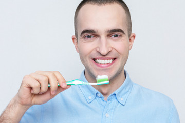 Handsome guy with a toothbrush and toothpaste, portrait, close-up