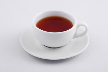 white tea cup with black tea on white background