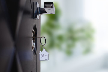 Silhouette of door keys hanging on the open door with blurred background