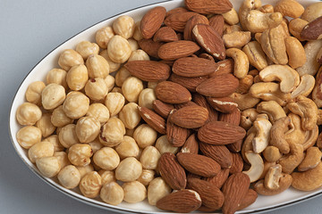 Three kinds of roasted nuts on plate. Healthy fats for health
