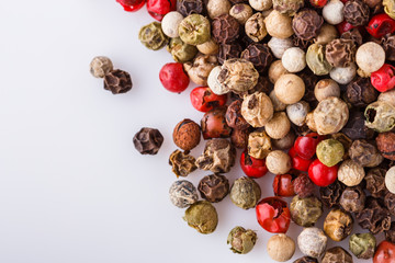 mix of peppercorns on white acrylic background