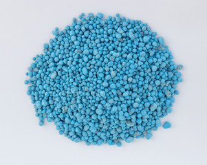 Blue chemical fertilizer on white background.