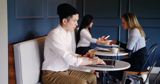 Businessman using laptop in cafeteria at office