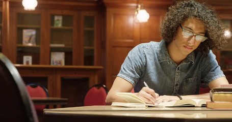 Man studying in the library - Powered by Adobe