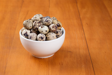 quail eggs on top of a wooden background.