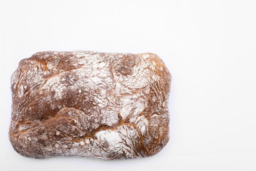 Black bread on the white background, top view
