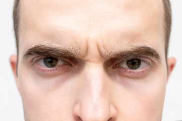 Face of gloomy man, man's eyes, cropped image, closeup, white background