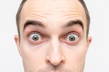 Obraz premium Face of surprised man, man's eyes, closeup, white background