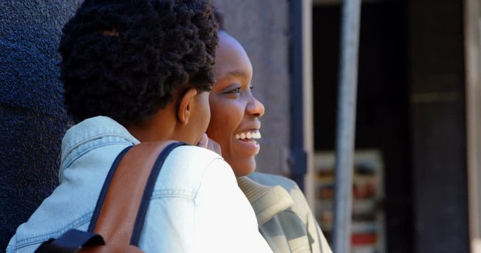 Twin sisters gossiping with each other in the city