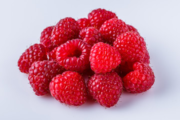 Juicy fresh natural raspberries on white acrylic background