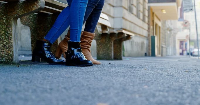 Twin sisters using mobile phone in the city