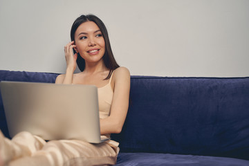 Charming young woman using laptop at home