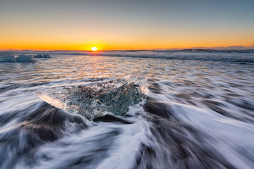 Golden ice on the black beach near Jokulsarlon glacier lagoon, daimond beach, South Iceland.