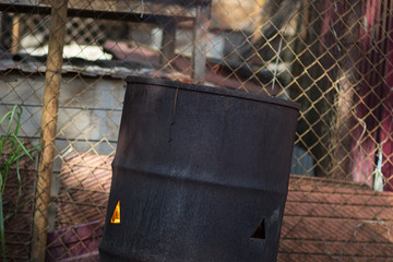 A hot searing fire in an old rusty iron barrel of garbage