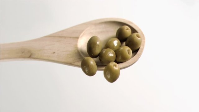 Olives falling in super slow motion from the spoon