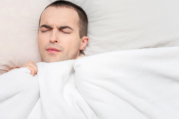 Person sleeps in his bed, portrait, top view, copy space, 16:9