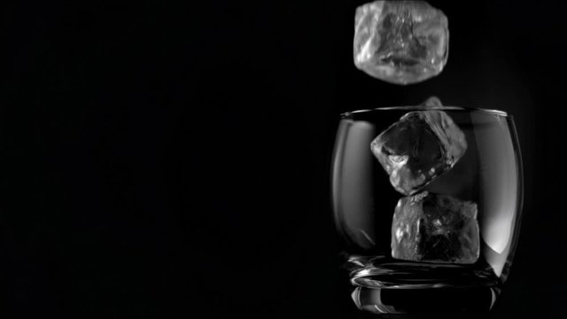 Ice cubes falling in super slow motion in a glass