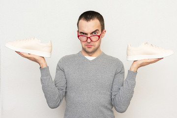 Dissatisfied nerd does not want to play sports, a man shows his sneakers to the camera, white...