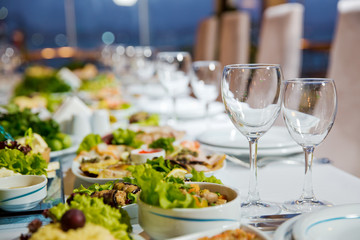 Salads and gums . Set of a dish with spoon, fork and knife on white table.Table setting on white table .