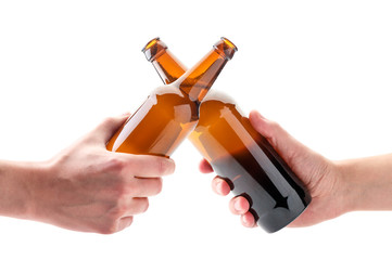 Two hands with beer bottles clink glasses on a white. Isolated