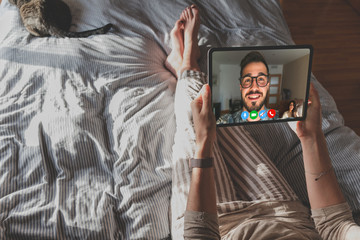 Back view of a woman talking to her friend about the plan on a video conference. Talking business from home. 