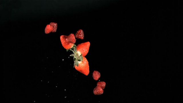 Red fruits being throw in super slow motion