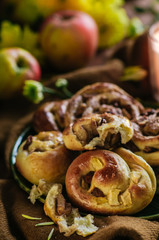 Freshly baked homemade buns with raisins and apples. Cozy autumn photo with buns in warm colors, flowers and candles.